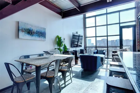 a view of a dining room with furniture large windows and wooden floor