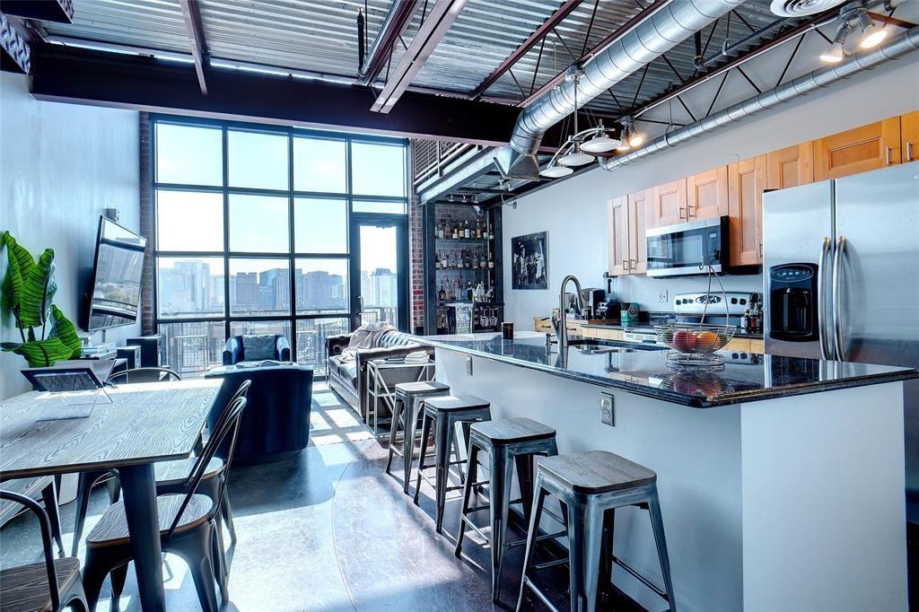 3110 Thomas Avenue, Unit 739 Dallas, TX 75204 - Photo 18 of 18 a kitchen with stainless steel appliances granite countertop a stove a refrigerator a kitchen island a dining table and chairs