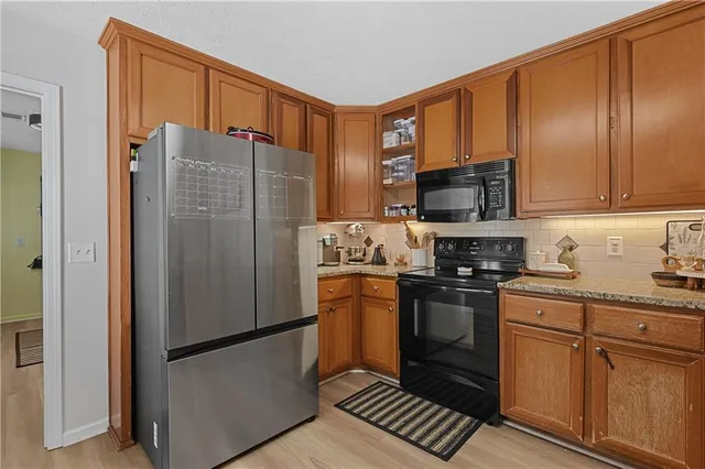 a kitchen with stainless steel appliances granite countertop a refrigerator stove and sink
