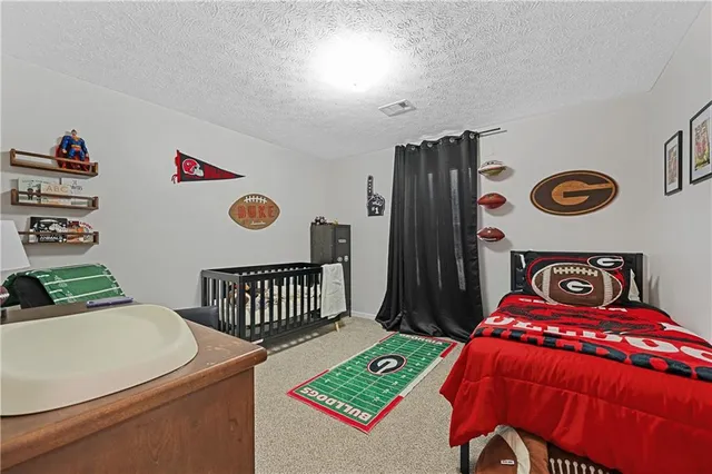 a bedroom with a bed and a table with a bookshelf