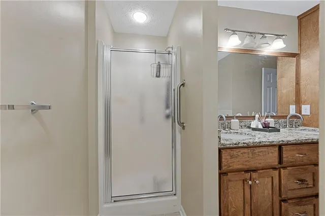 a bathroom with a granite countertop sink mirror and shower