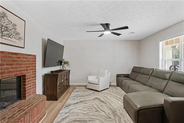 a living room with furniture a flat screen tv and a fireplace