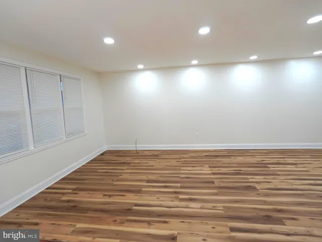 a view of room with wooden floor and windows