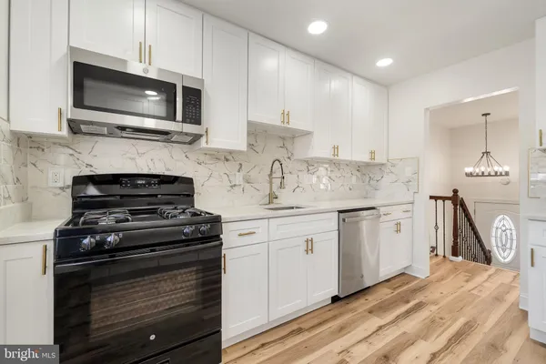 a kitchen with white cabinets and refrigerator