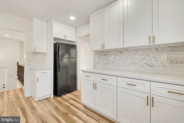 a kitchen with white cabinets sink and stove