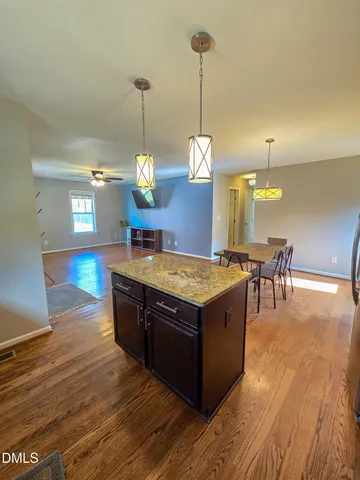 a kitchen with stainless steel appliances granite countertop a stove a sink and a wooden floor