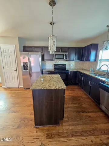 a kitchen with stainless steel appliances granite countertop a sink and a stove