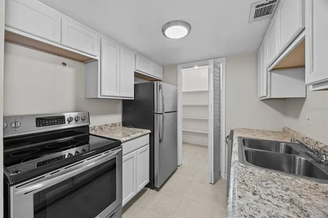 a kitchen with stainless steel appliances granite countertop a refrigerator and a stove