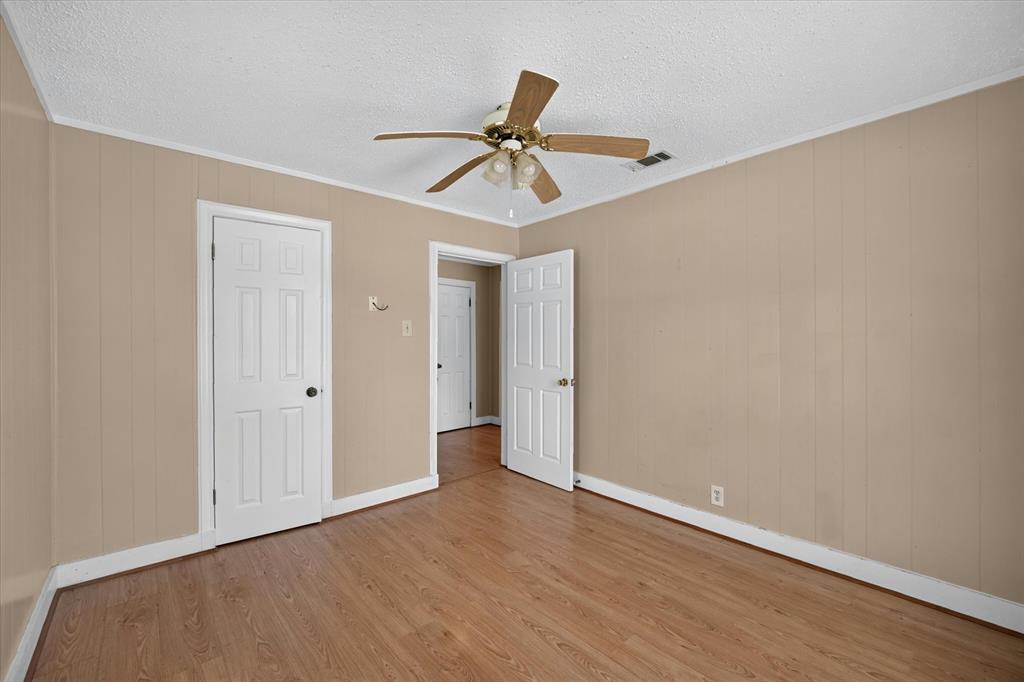 4450 Percy Street Lancaster, TX 75134 - Photo 14 of 18 Interior room featuring wood-finish flooring, light beige paneled walls, and white trim