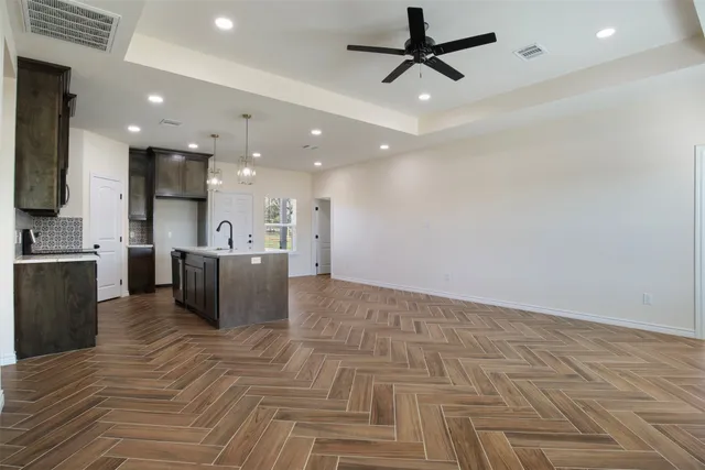 a kitchen with kitchen island granite countertop a refrigerator and a sink