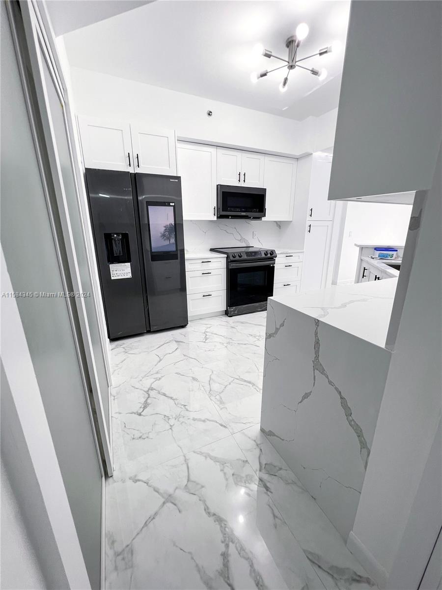 a kitchen with stainless steel appliances a refrigerator sink microwave and cabinets