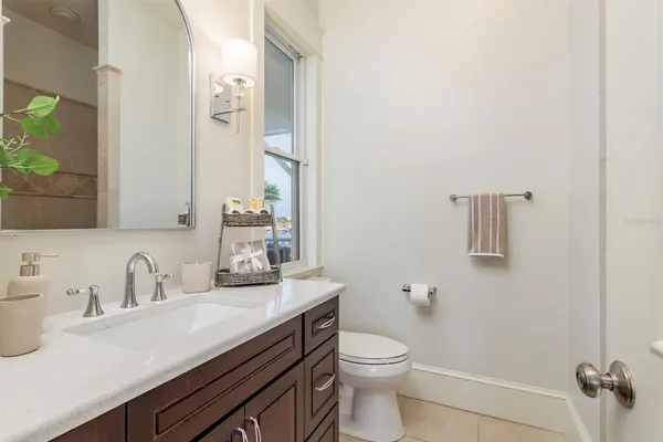 a bathroom with a granite countertop toilet a sink and a mirror