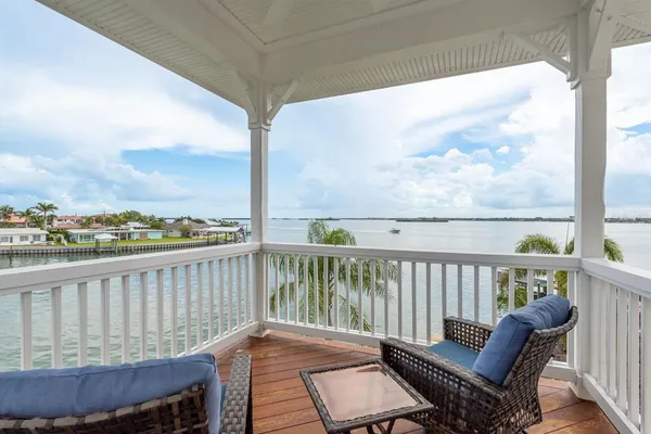 an empty room with windows and view of kitchen