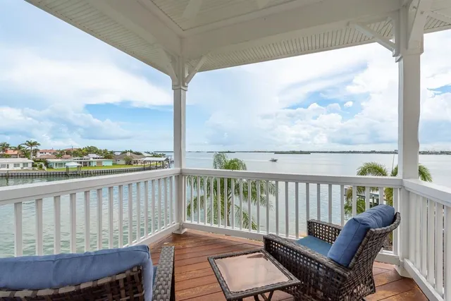 an empty room with windows and view of kitchen