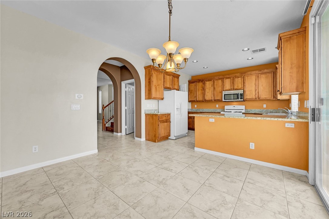 977 Sparkling Light Street Henderson, NV 89052 - Photo 27 of 75 This inviting kitchen and dining area features warm tones and ample space for everyday living.