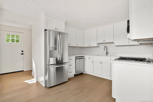 a kitchen with cabinets stainless steel appliances and a counter space