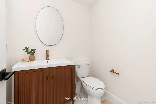 a bathroom with a sink a toilet and a mirror