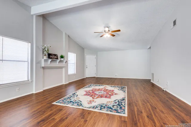 an empty room with wooden floor and window