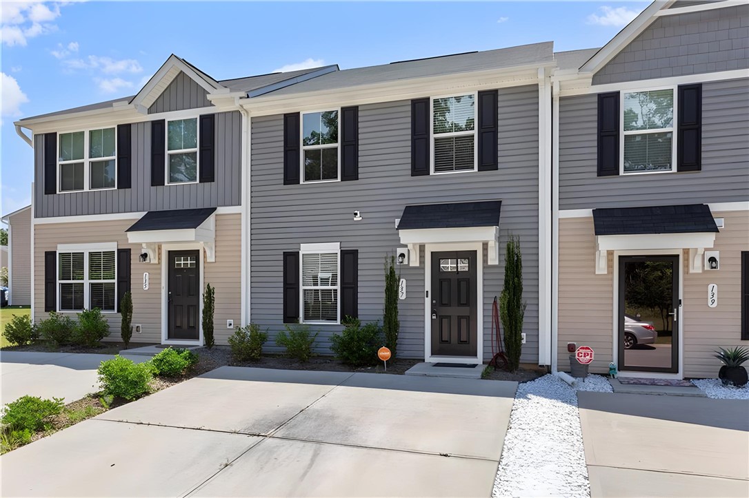 The townhomes feature attractive siding and practical front entryways with small landscaped areas.