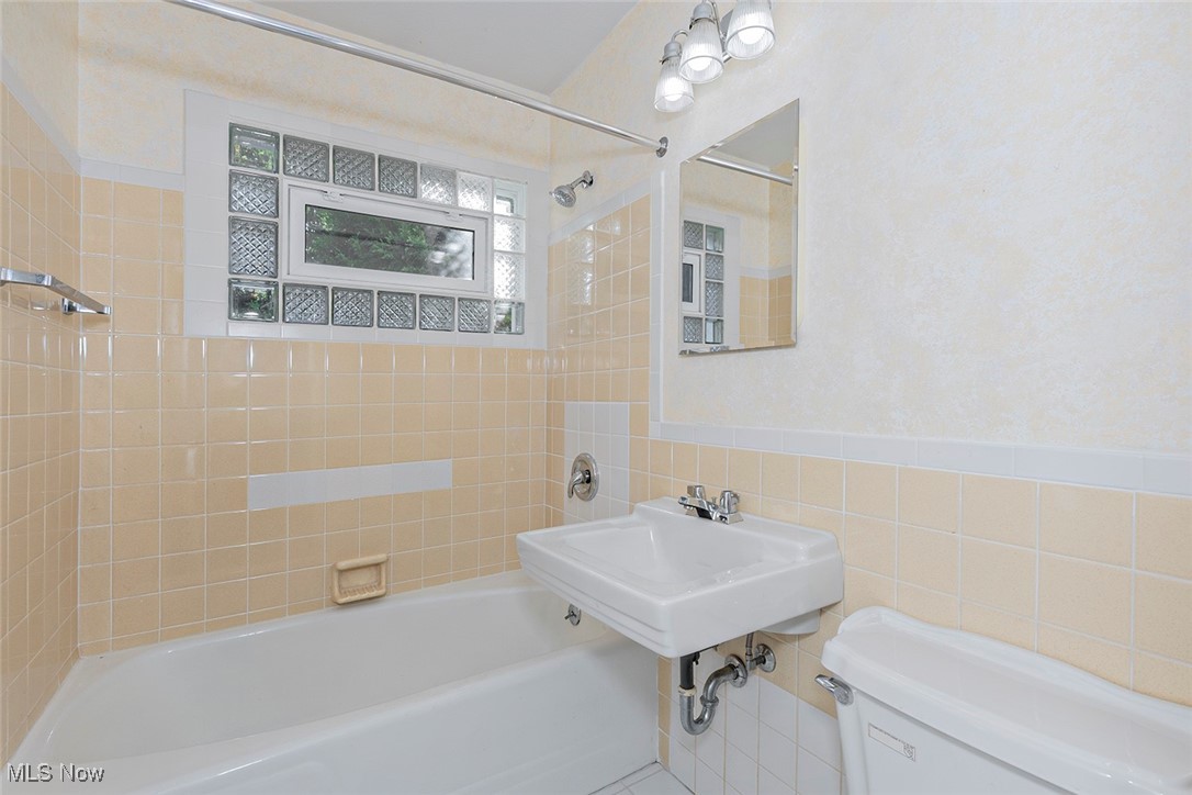 1691 Harwich Road Lyndhurst, OH 44124 - Photo 22 of 45 Full bath featuring tub / shower combination, tile walls, and a wainscoted wall