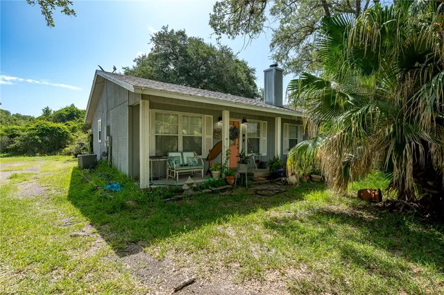 a view of a house with backyard sitting area and garden