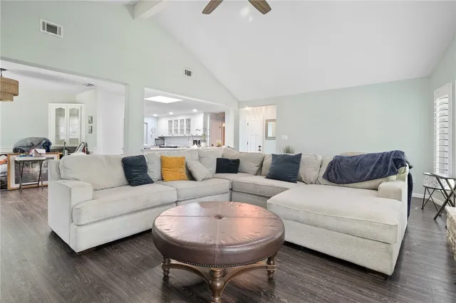 a living room with furniture a wooden floor and a chandelier
