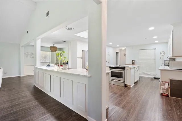 a kitchen with kitchen island granite countertop a sink cabinets and stainless steel appliances