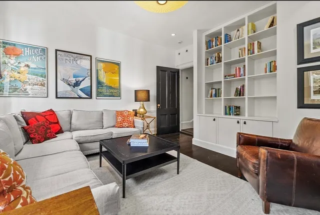 a living room with furniture a rug and a bookshelf