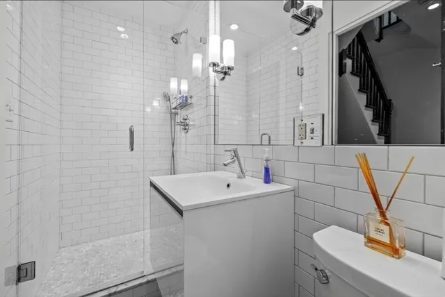 a bathroom with a sink a toilet and shower