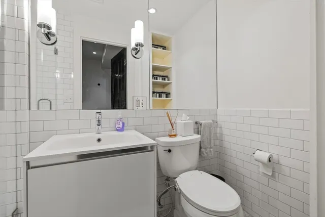 a bathroom with a sink a toilet and mirror