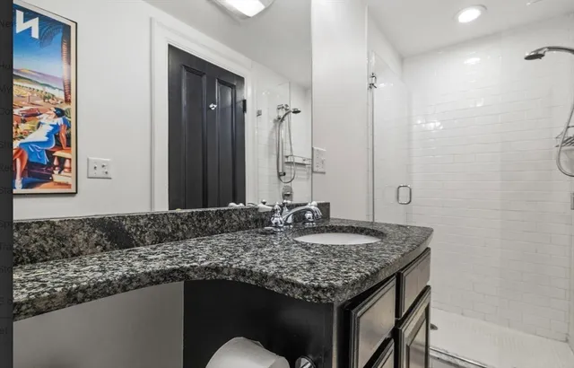 a bathroom with a granite countertop sink and a mirror