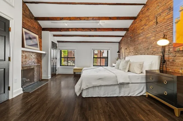 a spacious bedroom with a bed and a fireplace