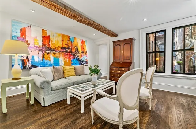 a living room with furniture fireplace and a large window