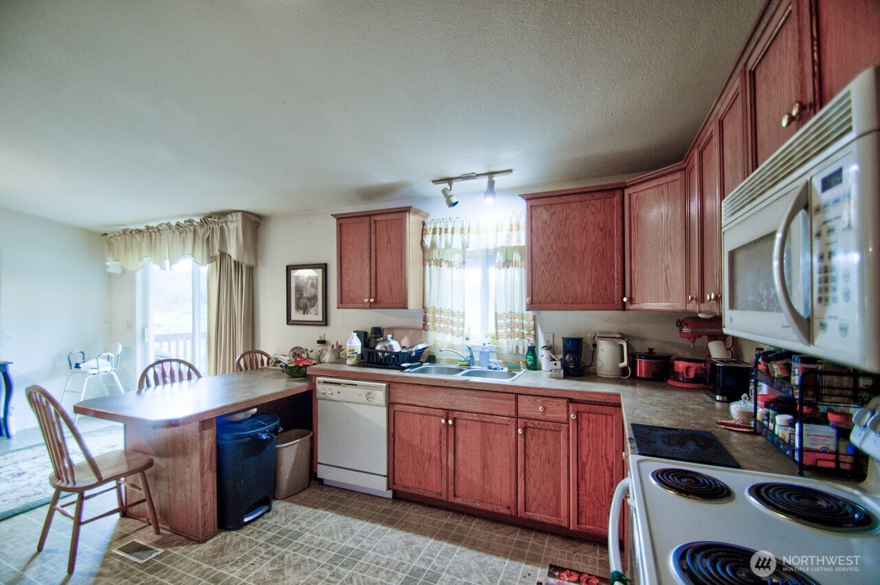 236 Tryon Road Onalaska, WA 98570 - Photo 19 of 40 a kitchen with granite countertop a sink stove and cabinets