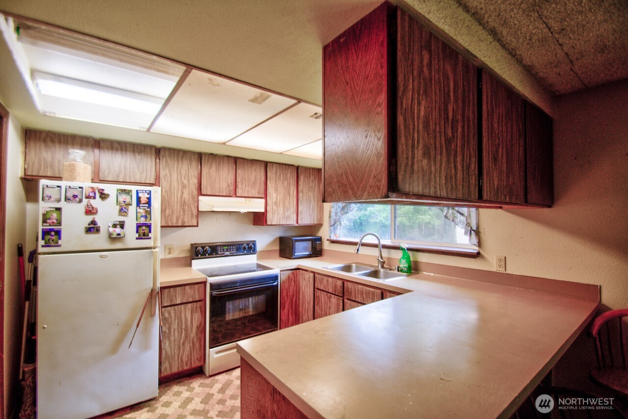 236 Tryon Road Onalaska, WA 98570 - Photo 26 of 40 a kitchen with a sink a stove and cabinets