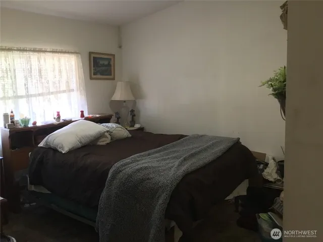 a bed sitting in a bedroom next to a window