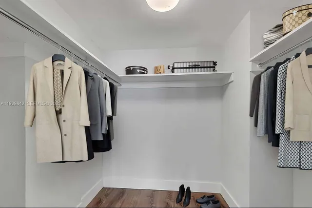 a view of walk in closet with clothes and shoes