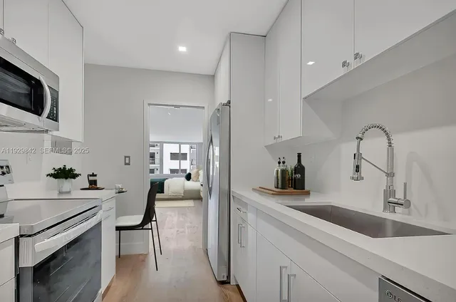 a kitchen with a sink dishwasher a stove and a refrigerator with wooden floor