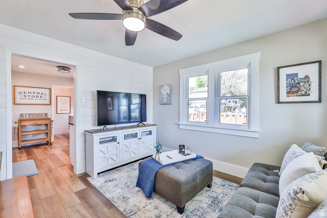 59 East 8680th Street South Sandy, UT 84070 - Photo 2 of 33 Open concept living area featuring wood-finish flooring, a ceiling fan with integrated lighting, and white shiplap accent wall paneling