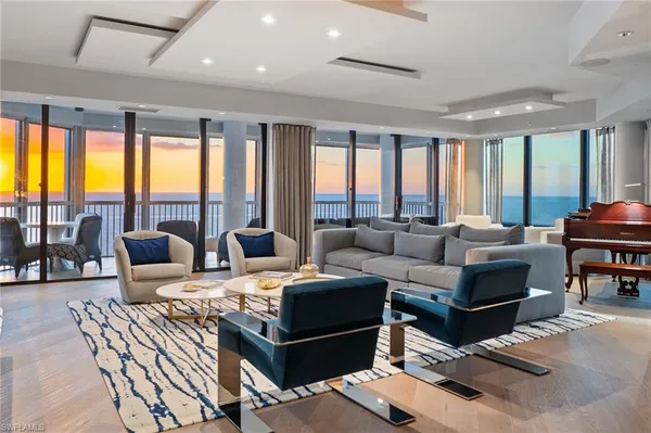 a living room with furniture and large windows