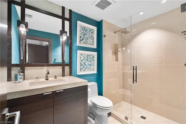 a bathroom with a sink toilet a mirror and shower