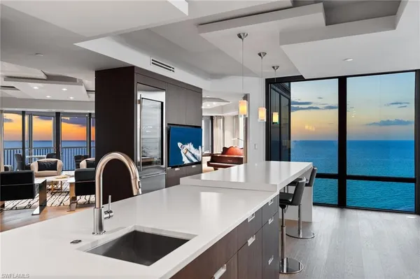 a kitchen with granite countertop a sink and white cabinets with wooden floor