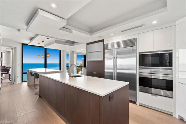 a kitchen with stainless steel appliances kitchen island granite countertop a refrigerator and a sink