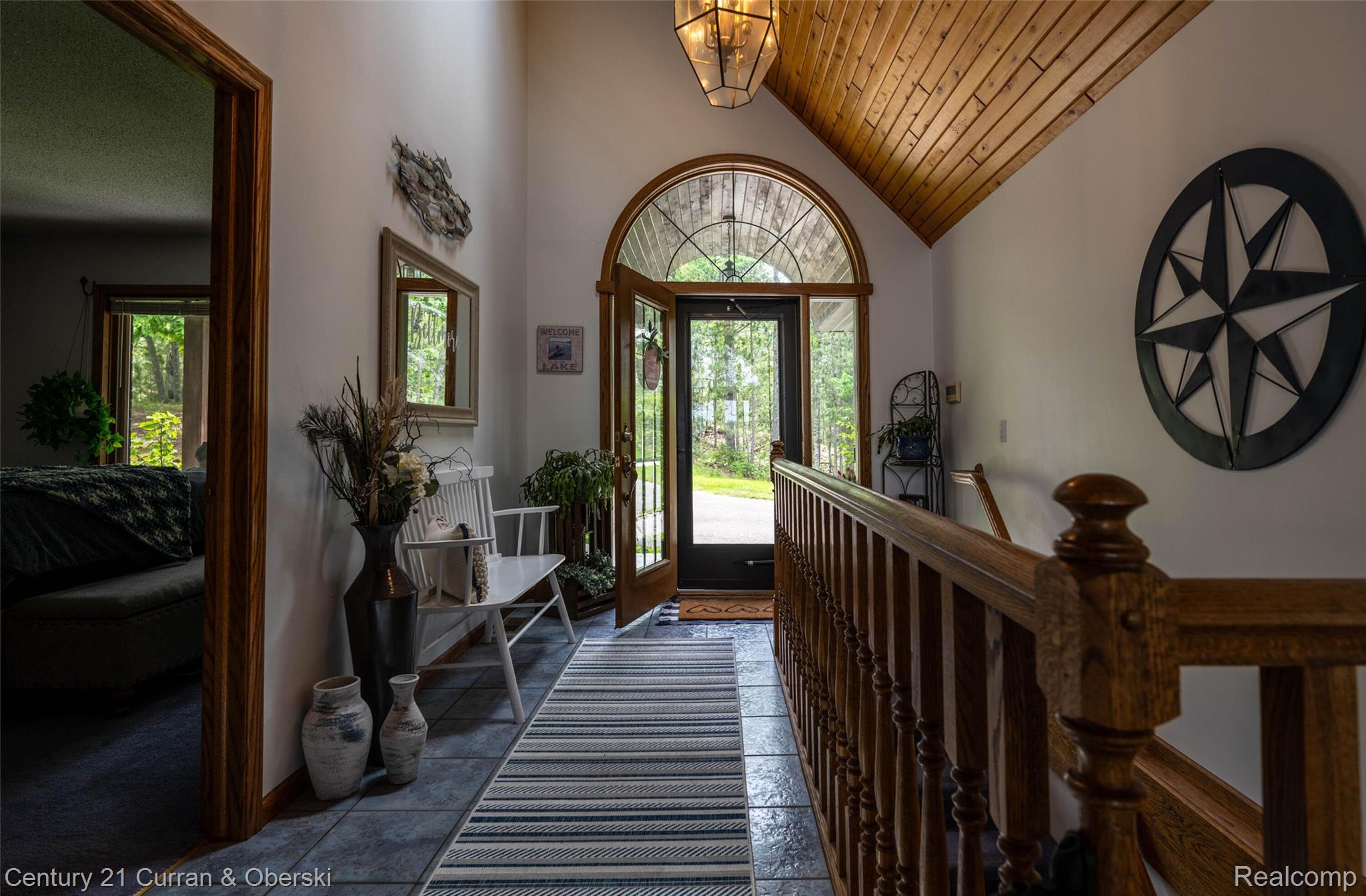 8775 Winding Rdg Drive Millersburg, MI 49759 - Photo 26 of 53 Vaulted wood-paneled ceiling entry hall featuring an arched transom window, a hardwood banister, and large format floor tiling