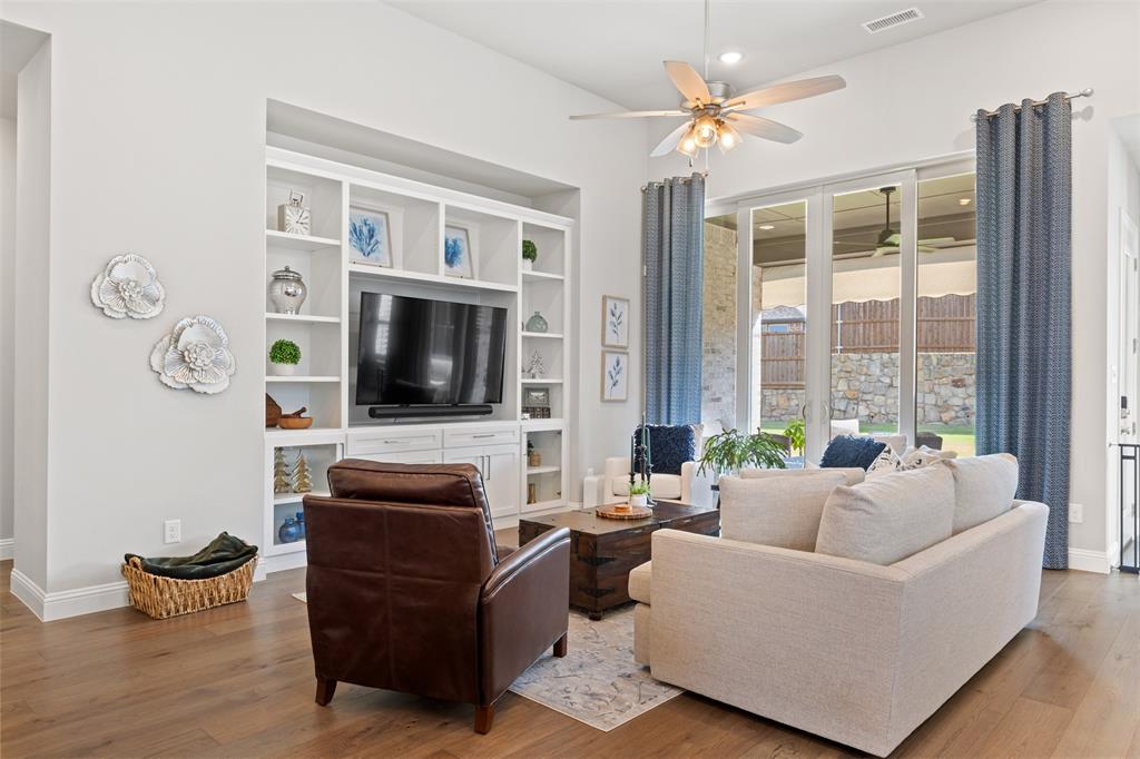 9716 Wilderness Road Little Elm, TX 75068 - Photo 14 of 39 Living room with integrated built-in cabinetry, wood-finish flooring, recessed lighting, and large sliding glass doors