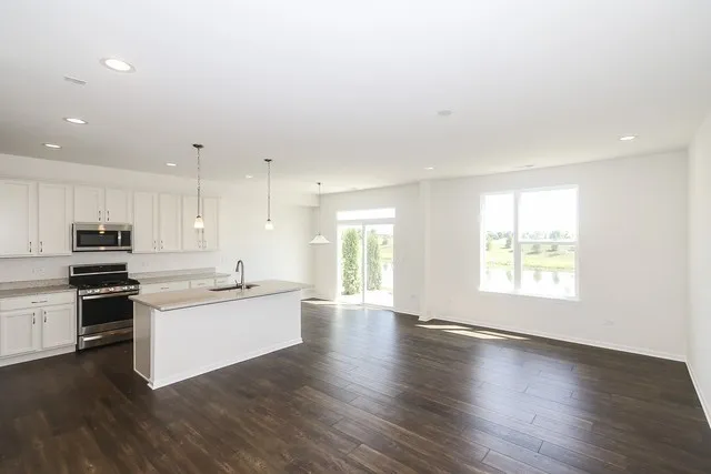 a kitchen with stainless steel appliances granite countertop a stove top oven a sink and a microwave