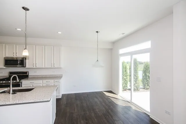 a kitchen that has a microwave a sink and a stove in it