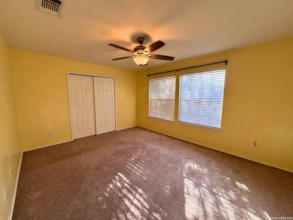 a view of a room with a ceiling fan and a window