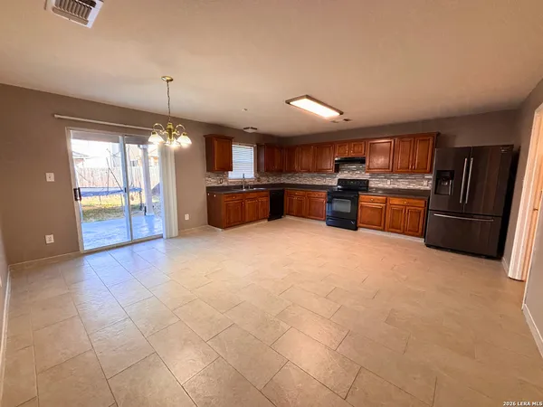 a kitchen with stainless steel appliances granite countertop a refrigerator and a stove top oven