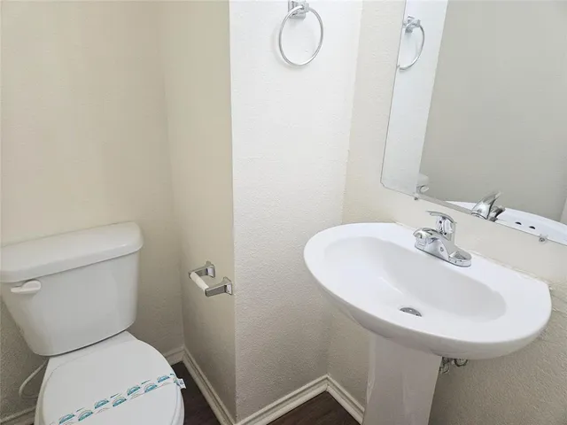 a bathroom with a sink a toilet and a mirror